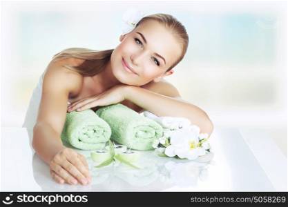 Portrait of a nice woman at spa, beautiful girl lying down on a massage table and enjoying health and beauty procedure, relaxation and pleasure concept