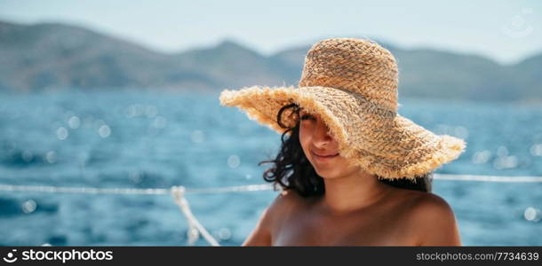 Portrait of a Nice Young Female Having Fun on the Cruise on Sailboat. Wearing Stylish Sun Hat and Enjoying Great Summer Vacation in Greece.. Pretty Woman on Sailboat