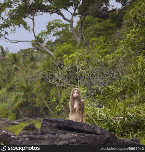 Portrait of a nude elegant lady in a green rainforest