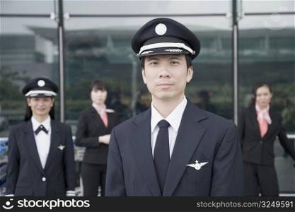 Portrait of a pilot with a female pilot and two cabin crews standing in the background