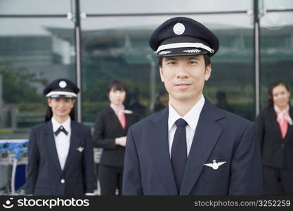 Portrait of a pilot with a female pilot and two cabin crews standing in the background