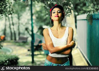 Portrait of a pin-up girl. American style, in a garden, wearing jeans and t-shirt
