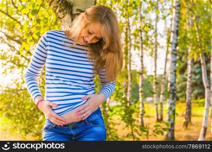 portrait of a pregnant girl hugging her belly