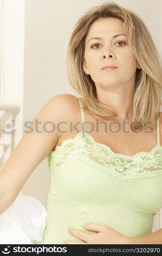 Portrait of a pregnant mid adult woman touching her abdomen