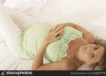 Portrait of a pregnant woman lying on the bed
