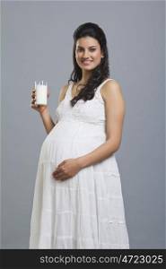 Portrait of a pregnant woman with a glass of milk