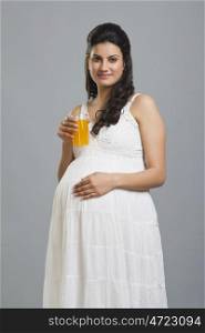 Portrait of a pregnant woman with a glass of orange juice