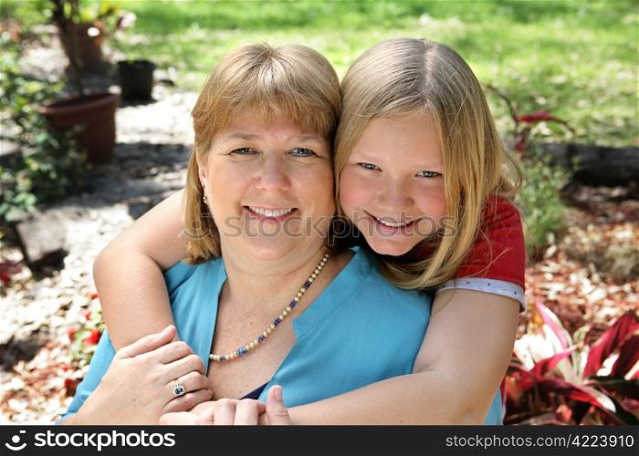 Portrait of a pretty blond mother and daughter in the garden.