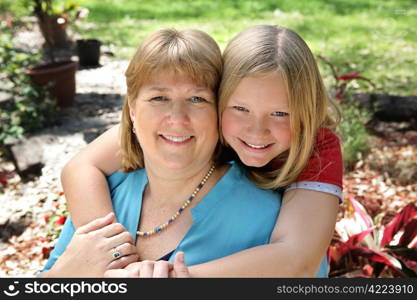 Portrait of a pretty blond mother and daughter in the garden.