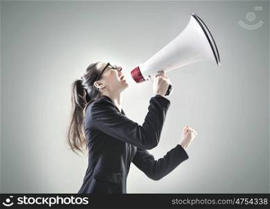 Portrait of a pretty businesswoman yelling over the megaphone
