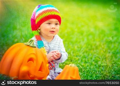 Portrait of a pretty child celebrating Halloween holiday, traditional American holiday with traditional pumpkins with carved smiling faces, happy time outdoors