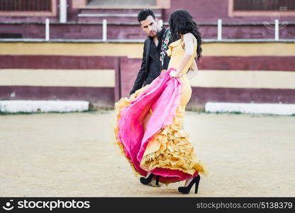 Portrait of a pretty couple, models of fashion, in a bullring. Spanish style