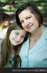 Portrait of a pretty mother and daughter together outdoors.