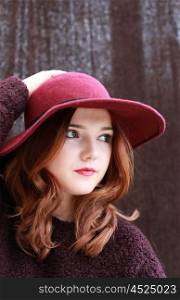 Portrait of a pretty teenage girl with redhair and floppy hat