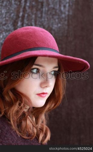 Portrait of a pretty teenage girl with redhair and floppy hat