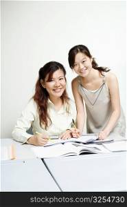 Portrait of a professor and a young woman smiling in the classroom