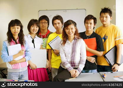 Portrait of a professor smiling with her students in a classroom