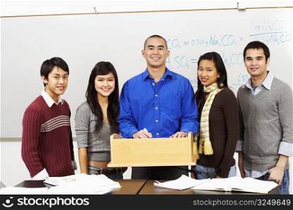 Portrait of a professor standing with his students in the classroom