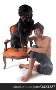 portrait of a purebred rottweiler and man in front of white background