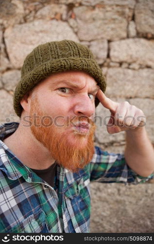 Portrait of a red haired hipster guy putting silly face