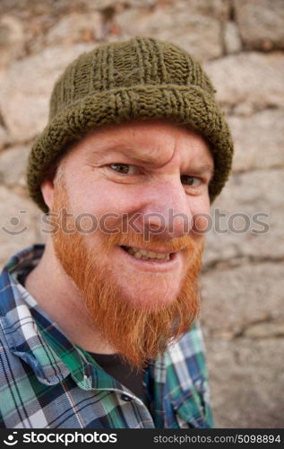 Portrait of a red haired hipster guy putting silly face