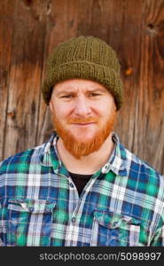 Portrait of a red haired hipster guy putting silly face