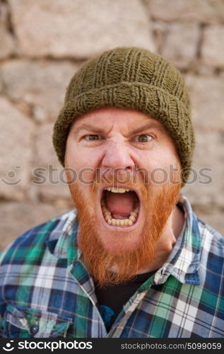 Portrait of a red haired hipster guy putting silly face