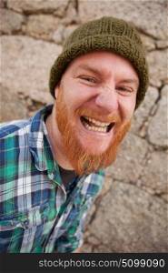 Portrait of a red haired hipster guy putting silly face