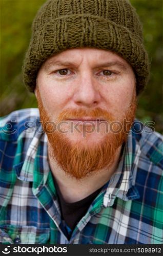 Portrait of a red haired man thinking in th forest