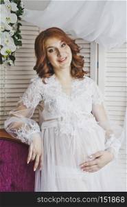 Portrait of a redhead girl in a transparent negligee.. Red-haired pregnant girl in a gentle environment 6828.