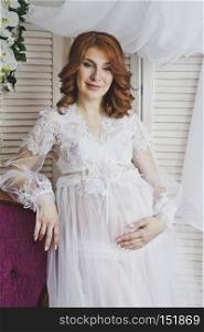 Portrait of a redhead girl in a transparent negligee.. Red-haired pregnant girl in a gentle environment 6829.