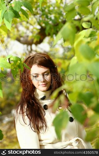Portrait of a redheaded girl near a tree
