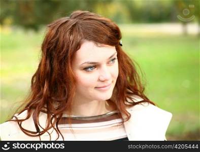 Portrait of a redheaded girl near a tree (autumn colors).