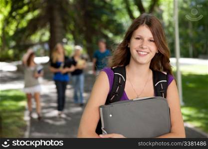 Portrait of a relaxed pretty college girl with binder