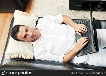 Portrait of a relaxed young guy using laptop at home indoor