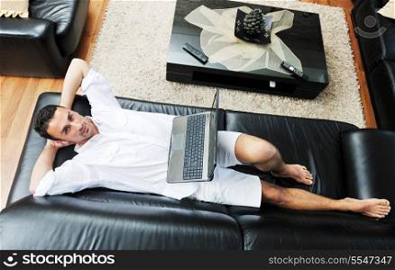 Portrait of a relaxed young guy using laptop at home indoor
