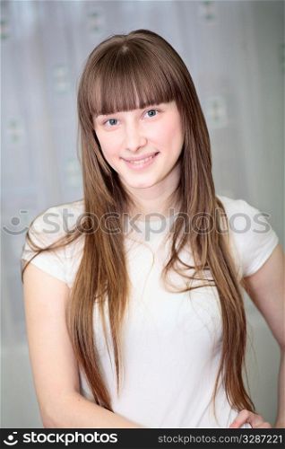 Portrait of a relaxed young woman smiling in living room