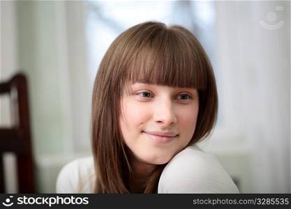 Portrait of a relaxed young woman smiling in the living room
