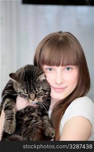 Portrait of a relaxed young woman smiling indoors with cat