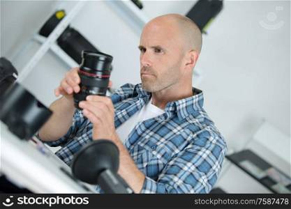 portrait of a repairman holding camera lens
