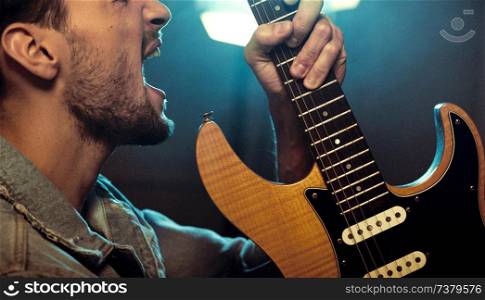 Portrait of a rock star playing a guitar and yelling