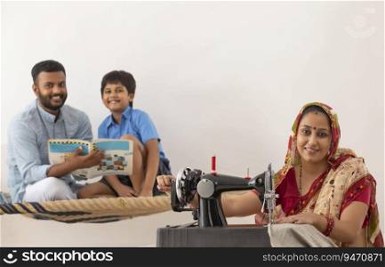 PORTRAIT OF A RURAL WOMAN SMILING AND LOOKING AT CAMERA WITH HUSBAND AND SON BEHIND SITTING AND POSING