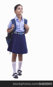 portrait of a school girl holding bag and smiling 