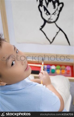 Portrait of a schoolboy painting in an art class