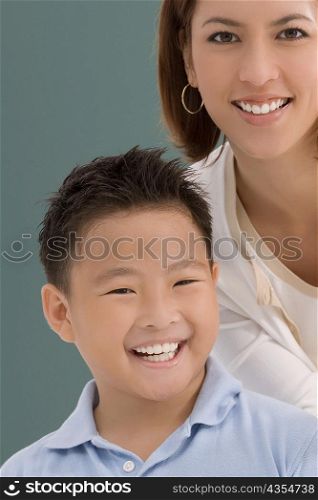 Portrait of a schoolboy with his female teacher smiling together in a classroom