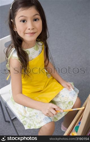 Portrait of a schoolgirl painting in an art class