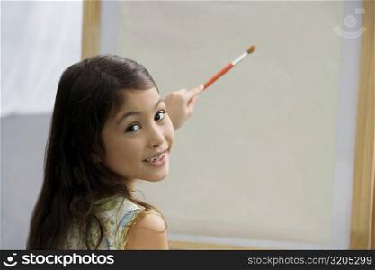 Portrait of a schoolgirl painting in an art class
