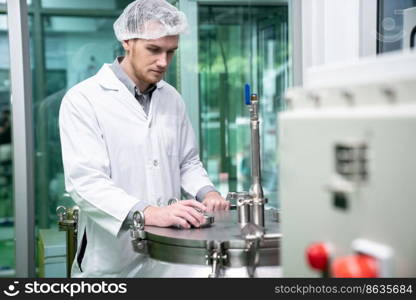 Portrait of a scientist, apothecary extracting cannabis oil using scientific equipment in a laboratory. Concept of cannabis extraction for alternative medicinal treatment. Portrait of a scientist, apothecary extracting cannabis oil in laboratory.