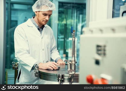 Portrait of a scientist, apothecary extracting cannabis oil using scientific equipment in a laboratory. Concept of cannabis extraction for alternative medicinal treatment. CBD oil extraction concept.. Portrait of a scientist, apothecary extracting cannabis oil in laboratory.