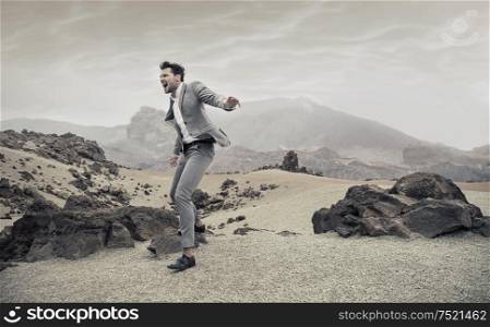 Portrait of a screaming young businessman on a desert